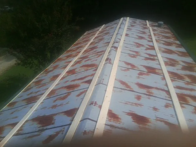 Rusted metal roof panels with new wood purlins before replacement — Storm Damage Roof Repair in Bagley by Roofing Brothers